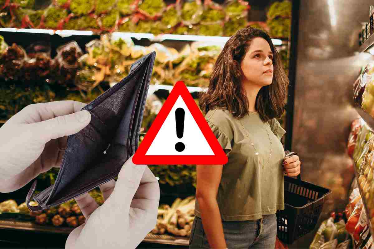Donna al supermercato davanti al banco verdura con portafoglio vuoto e segnale di pericolo: analisi del risparmio sui piatti vegetariani a marzo 2026.